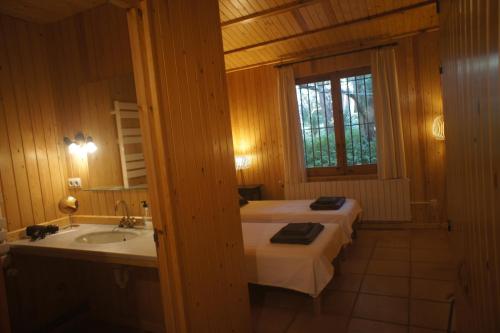 a bedroom with a bed and a sink and a window at La Bruguera de Púbol Villa & Eco Retreat Centre in Púbol