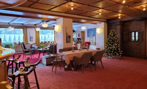 a room with a christmas tree and a table and chairs at B&B Villa Stelvio in Sta Maria Val Müstair
