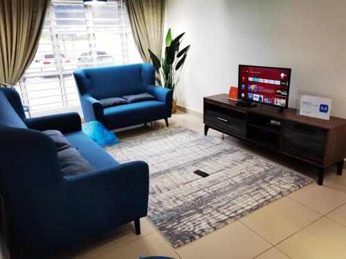 a living room with a blue couch and a tv at Wallaway2stay Kiara Nilai Apartment 3 Bedroom in Nilai