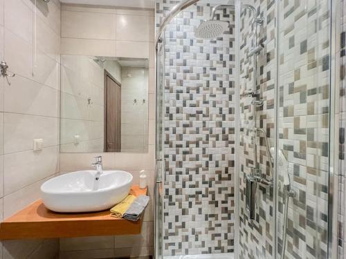 La salle de bains est pourvue d'un lavabo et d'une douche en verre. dans l'établissement Holiday Meteora A, à Kalambaka