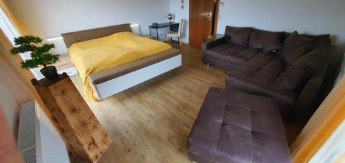 uma sala de estar com um sofá e uma cama em Die grüne Oase am RheinSteig 2 ZKBuWC em Neuwied