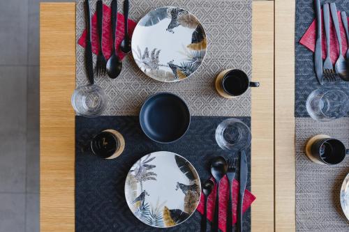 a table with plates and utensils on a table at Le Boutique Luxury Rooms diffused in Historic Center in Fiumicino