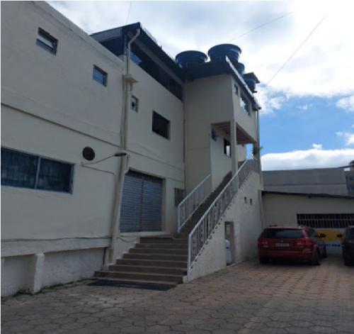 a white building with stairs and a car parked in front at Vitória Center Plaza Praça in Nova Friburgo