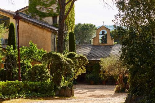a house with a church with a bell tower at La Bruguera de Púbol Villa & Eco Retreat Centre in Púbol