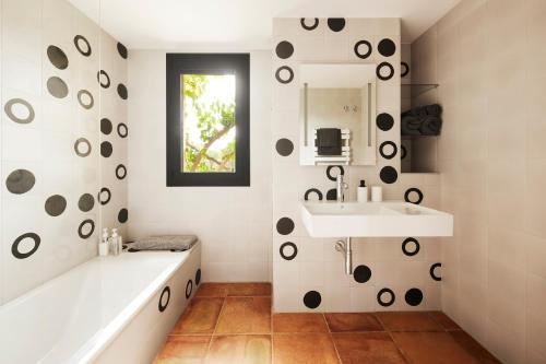 a bathroom with a tub and a sink and a mirror at La Bruguera de Púbol Villa & Eco Retreat Centre in Púbol