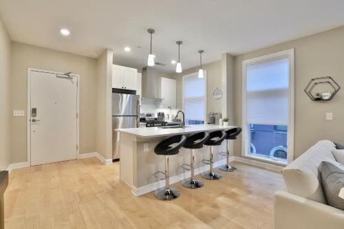 a kitchen with a counter and stools in a room at *New* XquisiteMidCenturyM0d~ Condo *OTR* w/Parking in Cincinnati