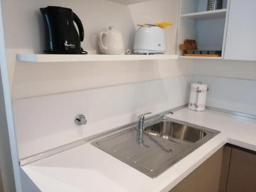 eine Küchenspüle auf einer weißen Arbeitsplatte in der Unterkunft Navigli Suites - De Santis in Mailand