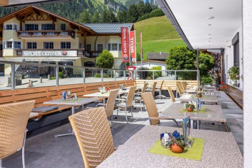 a restaurant with tables and chairs on a patio at Dorfstube in Holzgau