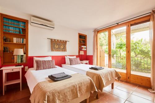 two beds in a room with red walls at La Bruguera de Púbol Villa & Eco Retreat Centre in Púbol