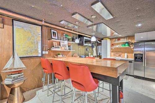 a kitchen with a large wooden bar with red chairs at Edmonds Apartment with Private Wine Cellar! in Edmonds