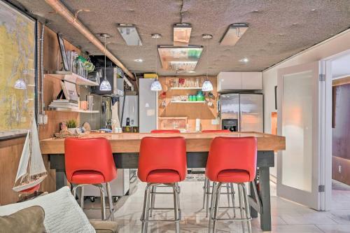 a kitchen with a bar with red bar stools at Edmonds Apartment with Private Wine Cellar! in Edmonds