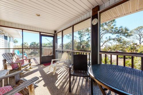 a screened in porch with a table and chairs at Seaside Searenity in Indian Pass