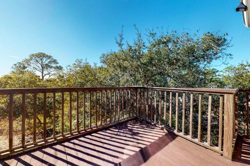 a wooden railing on a deck with trees in the background at Seaside Searenity in Indian Pass