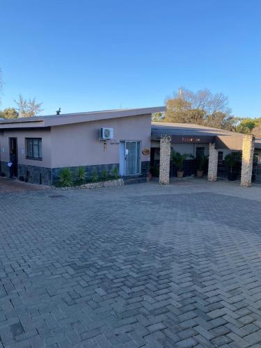 a building with a brick driveway in front of it at Cottonwood Guesthouse Oasis in Bloemfontein