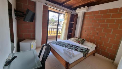 a small room with a small bed and a window at Hotel Bahía Yubarta in Bahía Solano