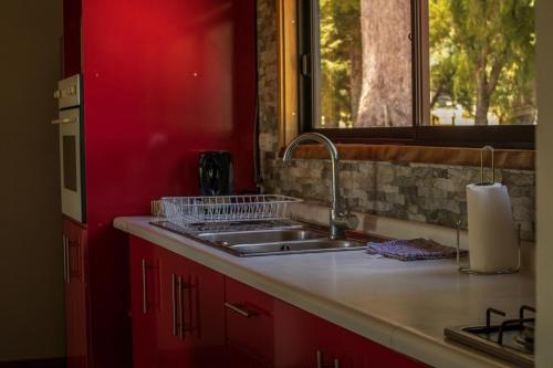 encimera de cocina con fregadero y ventana en Casa de campo Deluxe con tinaja de agua calinte gratis, en Panguipulli