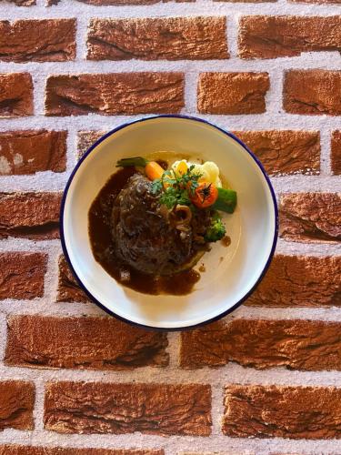 a plate of food on a brick wall at La Fleur de Lys in Gruyères