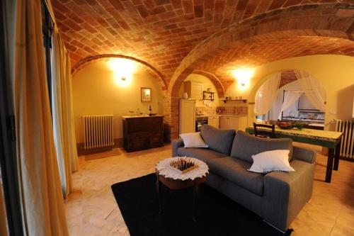 a living room with a couch and a kitchen at Piccolo Borgo Gagnoni in Sinalunga