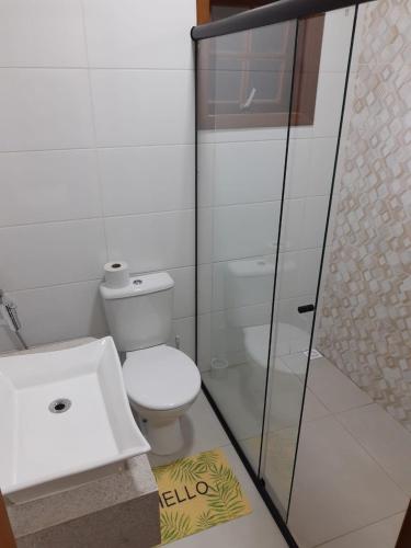 een badkamer met een wit toilet en een wastafel bij Casa Aconchego visconde de Mauá in Itatiaia