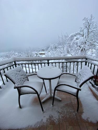 a table and chairs covered in snow on a balcony at Nefeles in Neochori