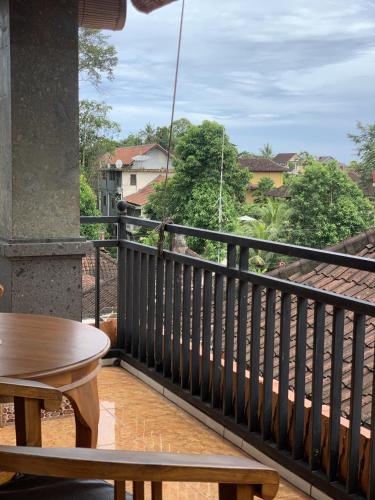 balcón con mesa y vistas a los árboles en Tude's Family Homestay, en Ubud