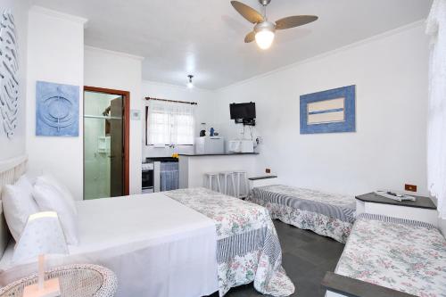 a hotel room with two beds and a ceiling fan at Chalés Mirante da Lagoinha in Ubatuba