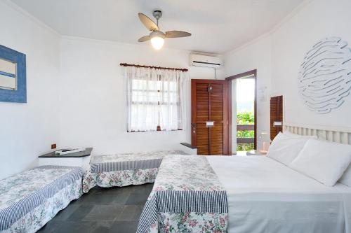 a hotel room with two beds and a window at Chalés Mirante da Lagoinha in Ubatuba