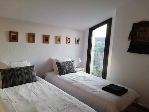 two beds in a room with a window at La Bruguera de Púbol Villa & Eco Retreat Centre in Púbol