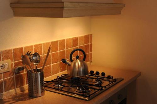 a tea kettle sitting on top of a stove at Piccolo Borgo Gagnoni in Sinalunga