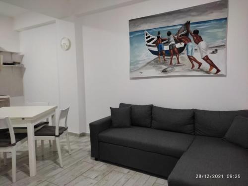 een woonkamer met een bank en een schilderij aan de muur bij Ca'Claudia Boavista in Sal Rei