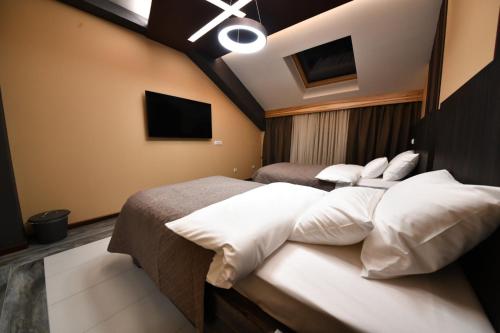 a bedroom with two beds with white pillows at Hotel Havana Loznica in Loznica