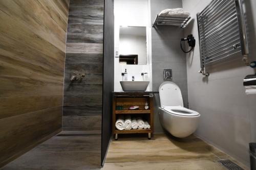 a bathroom with a white toilet and a sink at Hotel Havana Loznica in Loznica