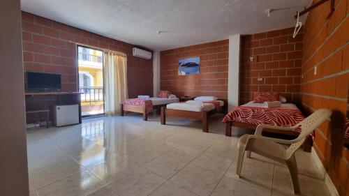 a room with two beds and a brick wall at Hotel Bahía Yubarta in Bahía Solano