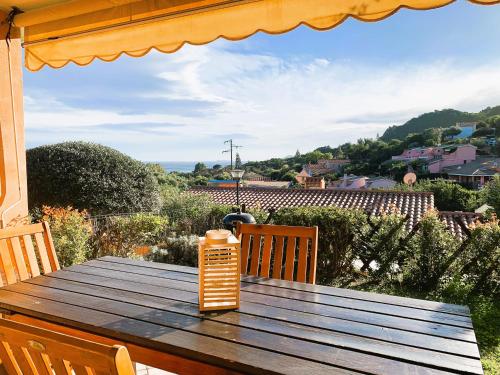 un tavolo in legno sul balcone di una casa di La Vela Summer House - FREE WIFI - 700mt from the beach a Costa Rei