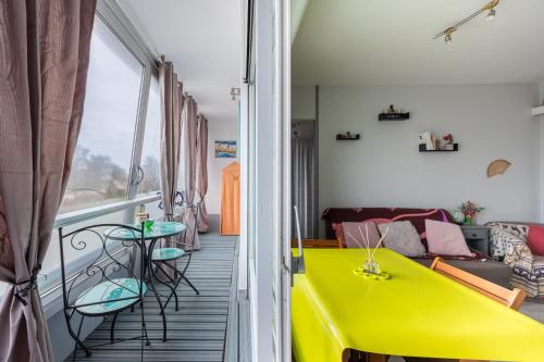 - un salon avec une table jaune et un canapé dans l'établissement Le Pavillon - Appartement à 30 m de la plage, à Courseulles-sur-Mer