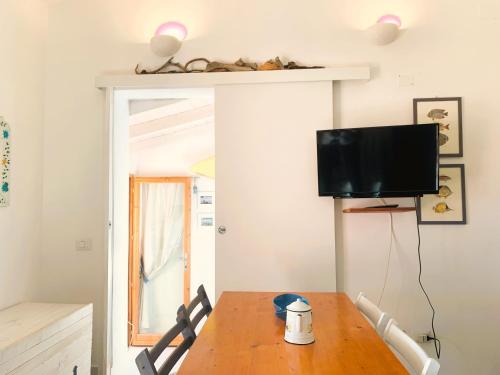 a dining room with a table and a tv at La Vela Summer House - FREE WIFI - 700mt from the beach in Costa Rei