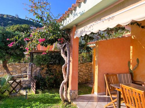 a house with a table and chairs on a patio at La Vela Summer House - FREE WIFI - 700mt from the beach in Costa Rei