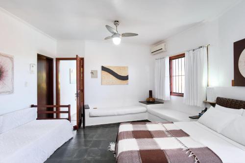 a white bedroom with a bed and a couch at Chalés Mirante da Lagoinha in Ubatuba