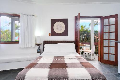 a bedroom with a large bed and a patio at Chalés Mirante da Lagoinha in Ubatuba