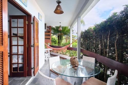 a glass table on the balcony of a house at Chalés Mirante da Lagoinha in Ubatuba