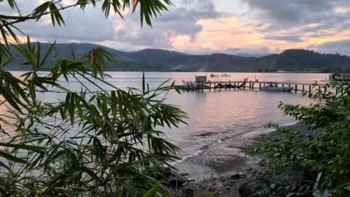 a dock on a body of water at sunset at Hotel Bahía Yubarta in Bahía Solano