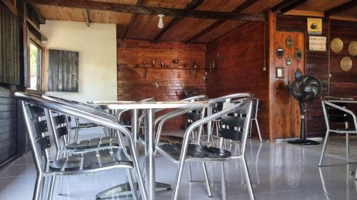 a table and chairs in a room with wooden walls at Hotel Bahía Yubarta in Bahía Solano