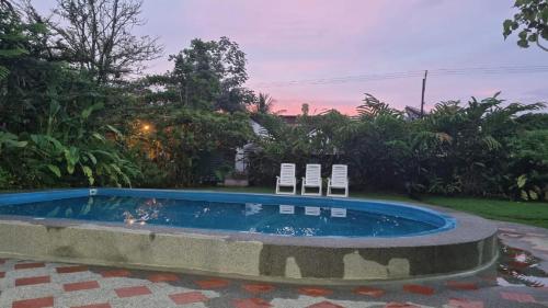 two chairs sitting next to a swimming pool at Hotel Bahía Yubarta in Bahía Solano