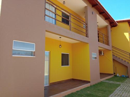 - une vue sur l'extérieur d'une maison jaune dans l'établissement Pousada Nobre, à São Miguel do Gostoso