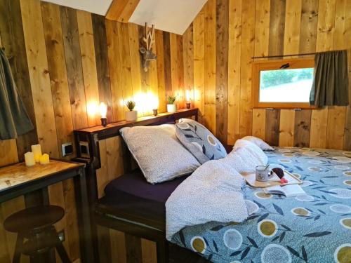 a bedroom with a bed and a desk with candles at Cab'ânes du Pibeste in Ségus