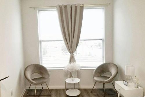 two chairs and a table in front of a window at Book Cozy King Bed Now 25 Percent OFF Spring Special! in Carteret