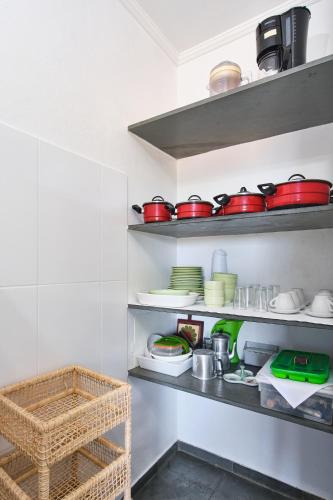 a kitchen with shelves filled with pots and pans at Chalés Mirante da Lagoinha in Ubatuba