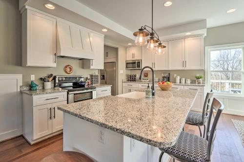 a kitchen with white cabinets and a granite counter top at Morrisonville Manor with Fire Pit and Hot Tub! in Britain