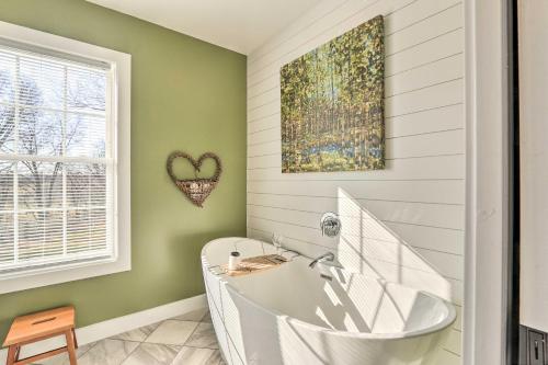 a bathroom with a white tub and a heart picture at Morrisonville Manor with Fire Pit and Hot Tub! in Britain