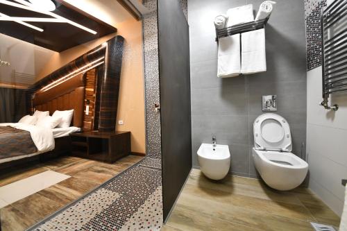 uma pequena casa de banho com um WC e uma cama em Hotel Havana Loznica em Loznica